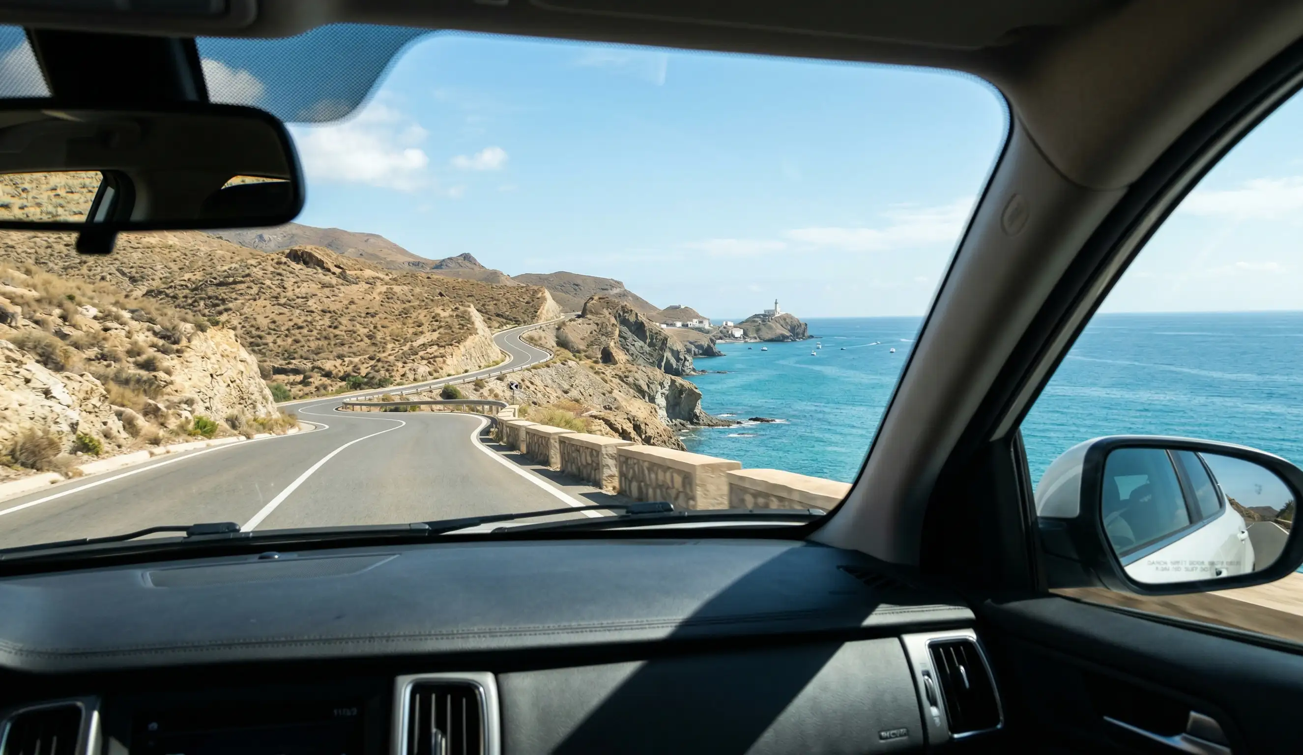 Paisaje de la costa de Almería y el Arrecife de las Sirenas visto desde el interior de un vehículo de traslado privado.